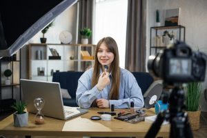Female beauty blogger recording online tutorial on camera